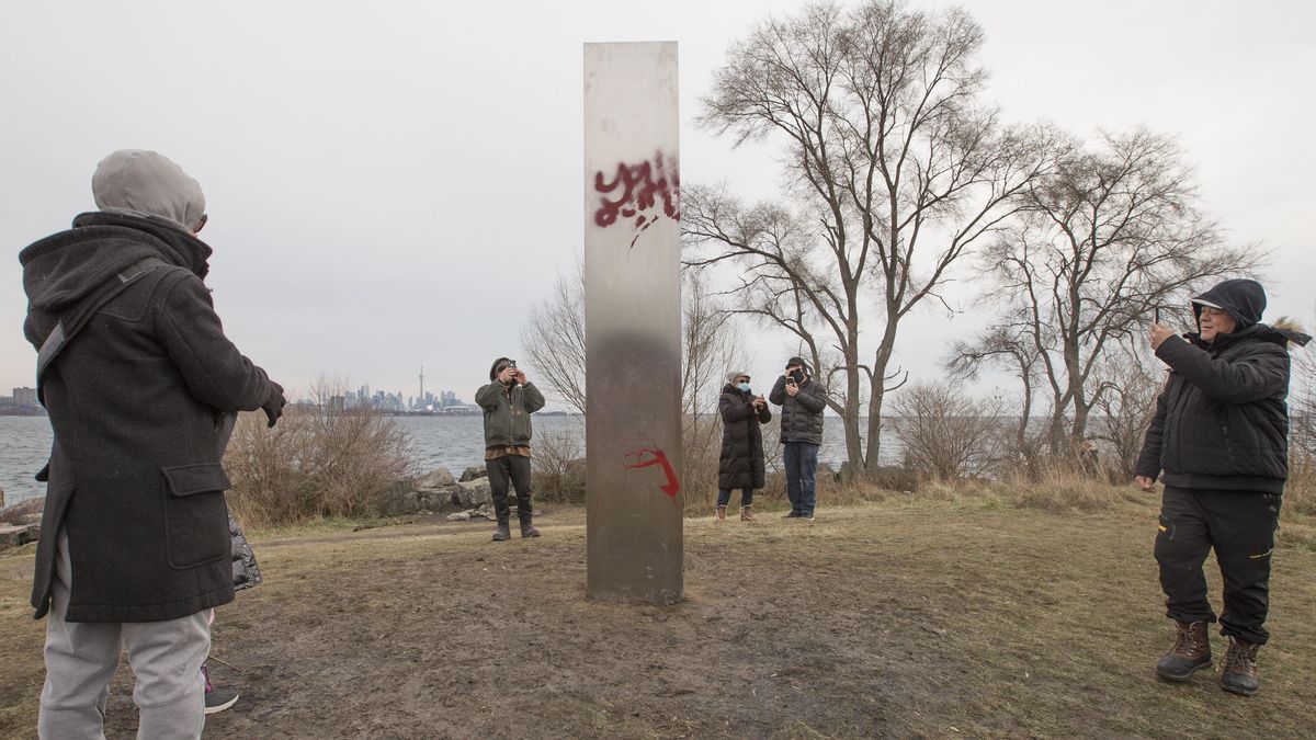 Varios habitantes de Toronto fotografían el misterioso monolito, que ya ha sido vandalizado con grafitis. Varios habitantes de Toronto fotografían el misterioso monolito, que ya ha sido vandalizado con grafitis.