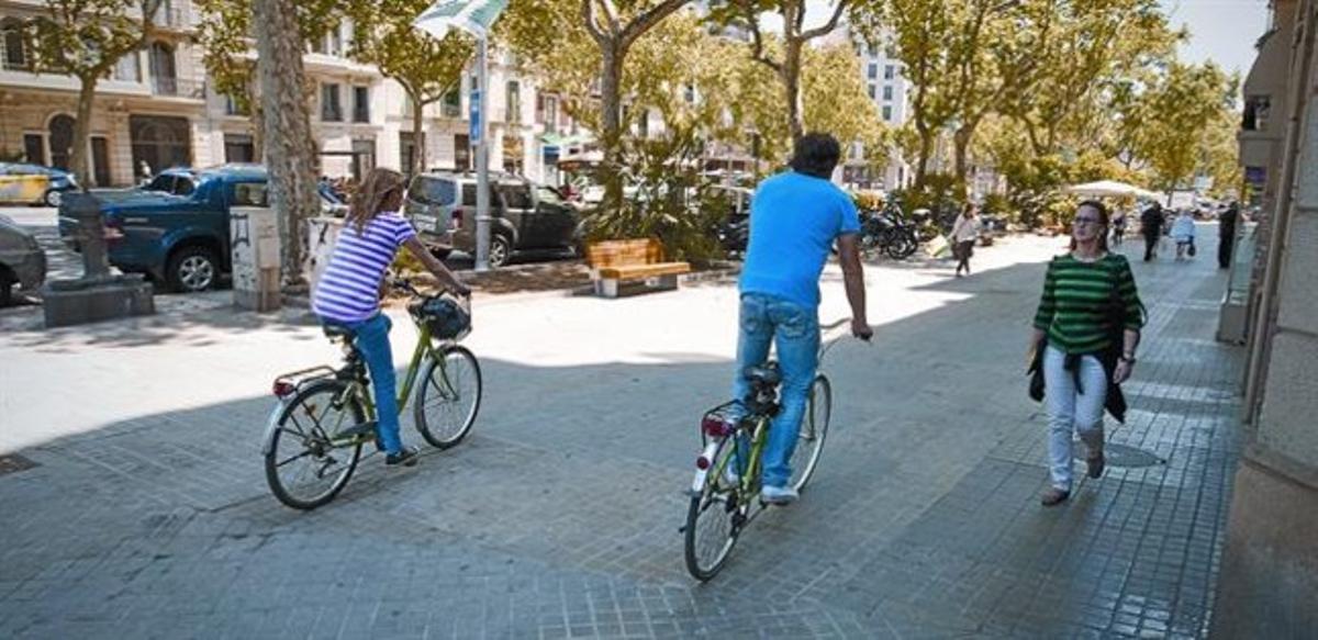 Unos ciclistas en la esquina del paseo de Sant Joan con Aragó.