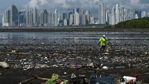 Un hombre recoge basura en la playa del este, en Panamá. 