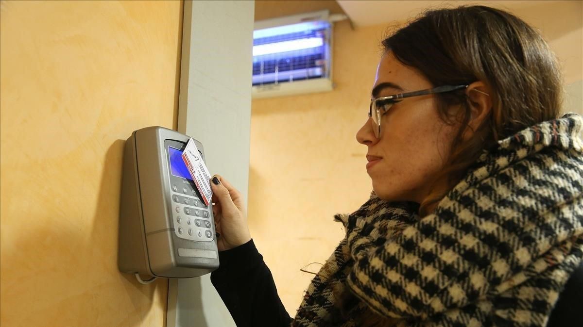 Una joven fichando la entrada en su empresa. Una joven fichando la entrada en su empresa.