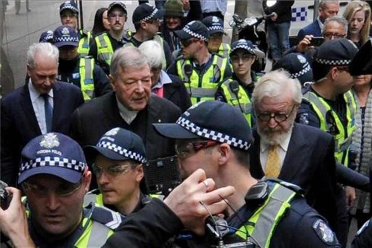 El cardenal George Pell (en el centro) sale de la Audiencia, en Melbourne.