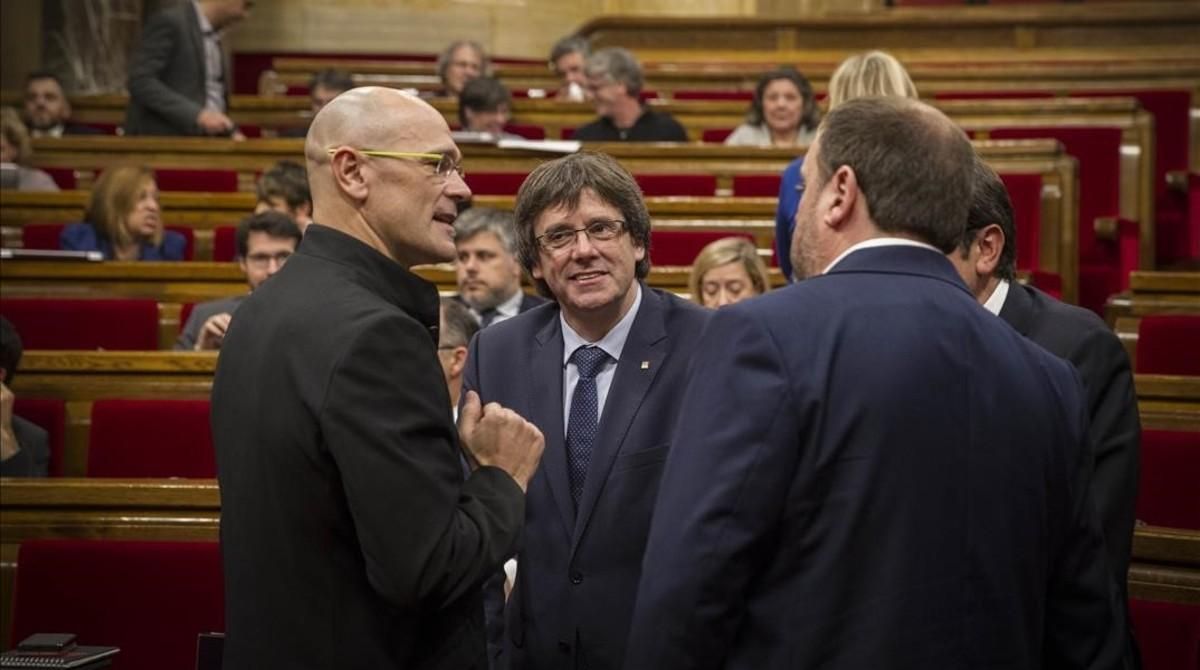 El ’president’ Carles Puigdemont, el vicepresidente Oriol Junqueras y el ’conseller’ Raül Romeva, en el hemiciclo del Parlament. El ’president’ Carles Puigdemont, el vicepresidente Oriol Junqueras y el ’conseller’ Raül Romeva, en el hemiciclo del Parlament.