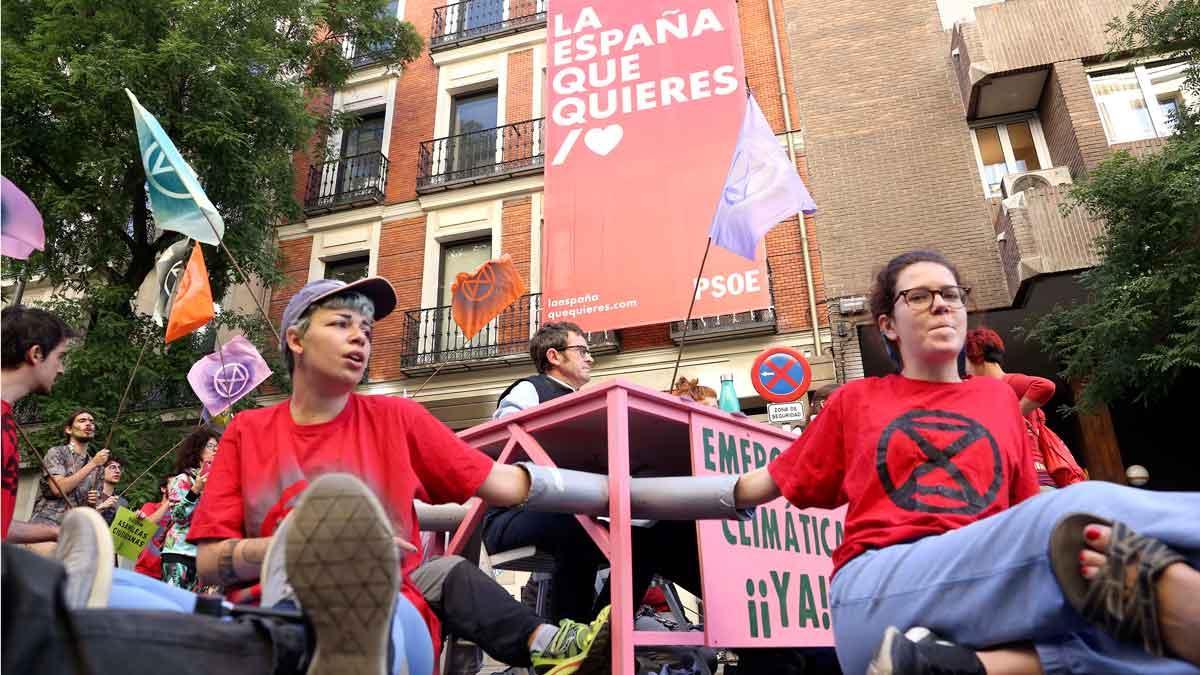 Miembros de una entidad ecologista se encadenan frente a la sede del PSOE en Madrid.