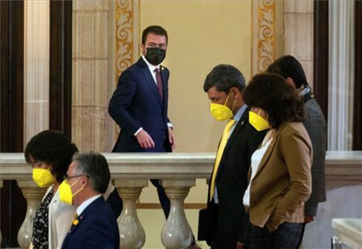 El candidato de ERC, Pere Aragonés, junto a varios diputados de JxCat, en los pasillos del Parlament durante un receso del debate de investidura del nuevo presidente de la Generalitat. El candidato de ERC, Pere Aragonés, junto a varios diputados de JxCat, en los pasillos del Parlament durante un receso del debate de investidura del nuevo presidente de la Generalitat.
