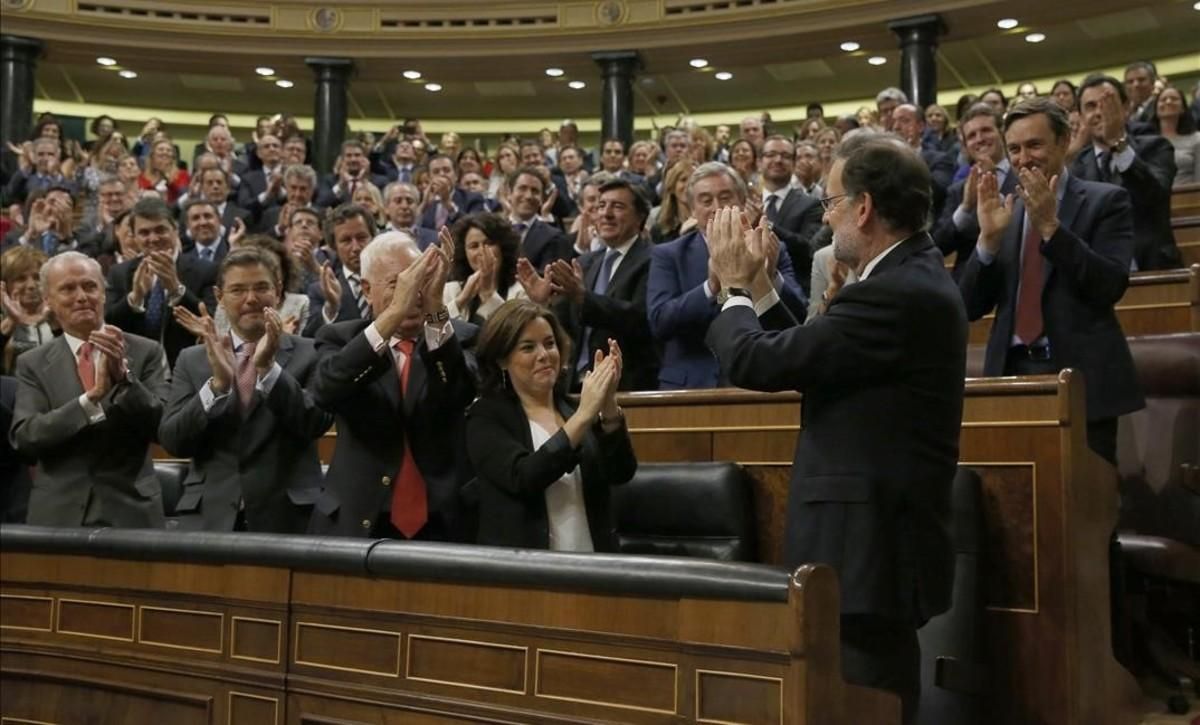 El grupo parlamentario, varios ministros y la vicepresidenta, Soraya Sáenz de Santamaría, aplauden a Mariano Rajoy tras ganar la votación del debate de investidura, el pasado sábado 29 de octubre. El grupo parlamentario, varios ministros y la vicepresidenta, Soraya Sáenz de Santamaría, aplauden a Mariano Rajoy tras ganar la votación del debate de investidura, el pasado sábado 29 de octubre.