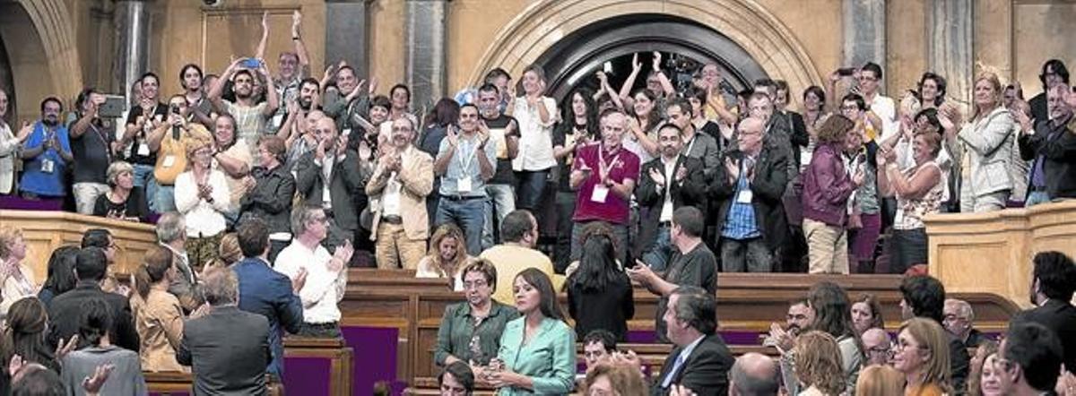 La tribuna de invitados del Parlament aplaude tras la aprobación de la ley, ayer. La tribuna de invitados del Parlament aplaude tras la aprobación de la ley, ayer.