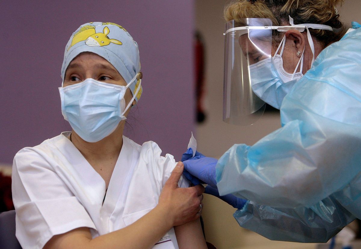 Mónica, una auxiliar de enfermería y la trabajadora más joven de la residencia de mayores Los Olmos, en Guadalajara, ha sido la primera sanitaria española en recibir la vacuna contra la covid-19. Mónica, una auxiliar de enfermería y la trabajadora más joven de la residencia de mayores Los Olmos, en Guadalajara, ha sido la primera sanitaria española en recibir la vacuna contra la covid-19.