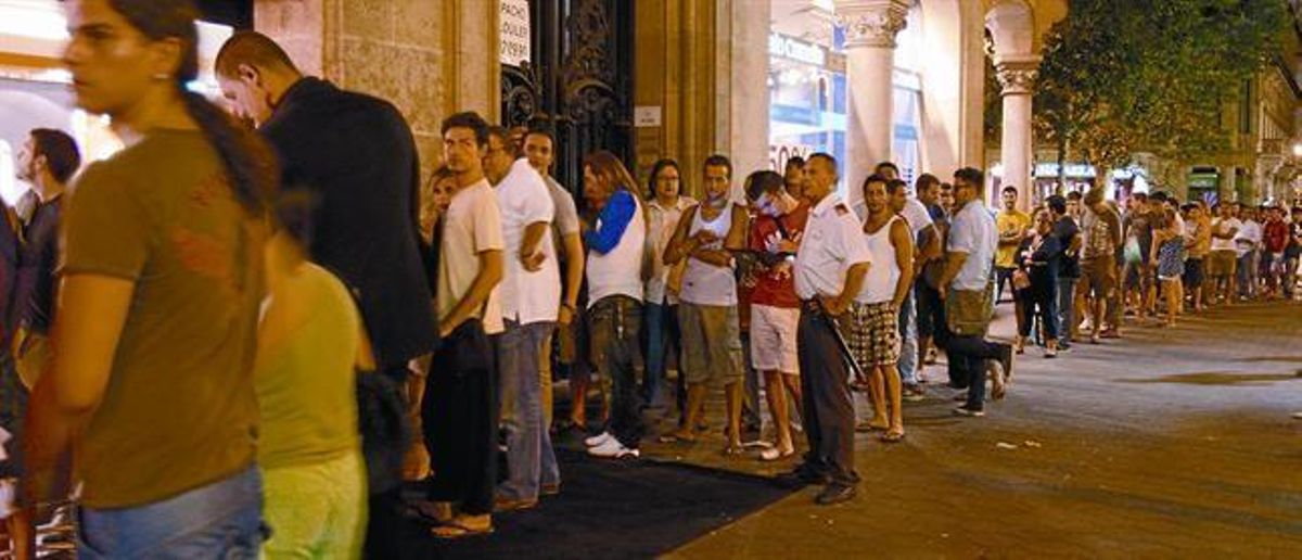 Cola de clientes ante la tienda de Orange en el paseo de Gràcia de Barcelona, el jueves por la noche. Cola de clientes ante la tienda de Orange en el paseo de Gràcia de Barcelona, el jueves por la noche.