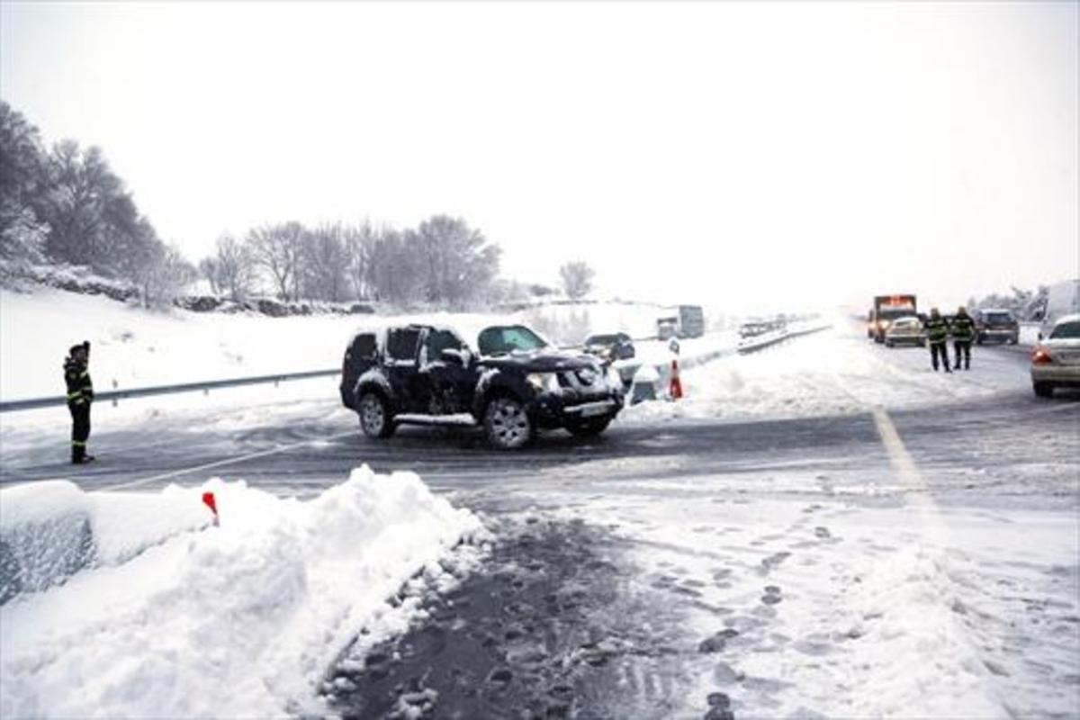 Agentes de la policía ayudan el domingo a los vehículos atrapados en la AP-6 por la tormenta de nieve.