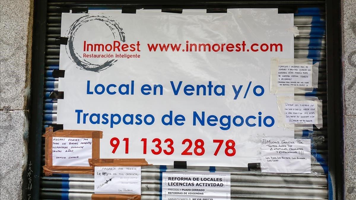 Cartel que anuncia la venta o traspaso en la persiana de una cafetería de Madrid. Cartel que anuncia la venta o traspaso en la persiana de una cafetería de Madrid.