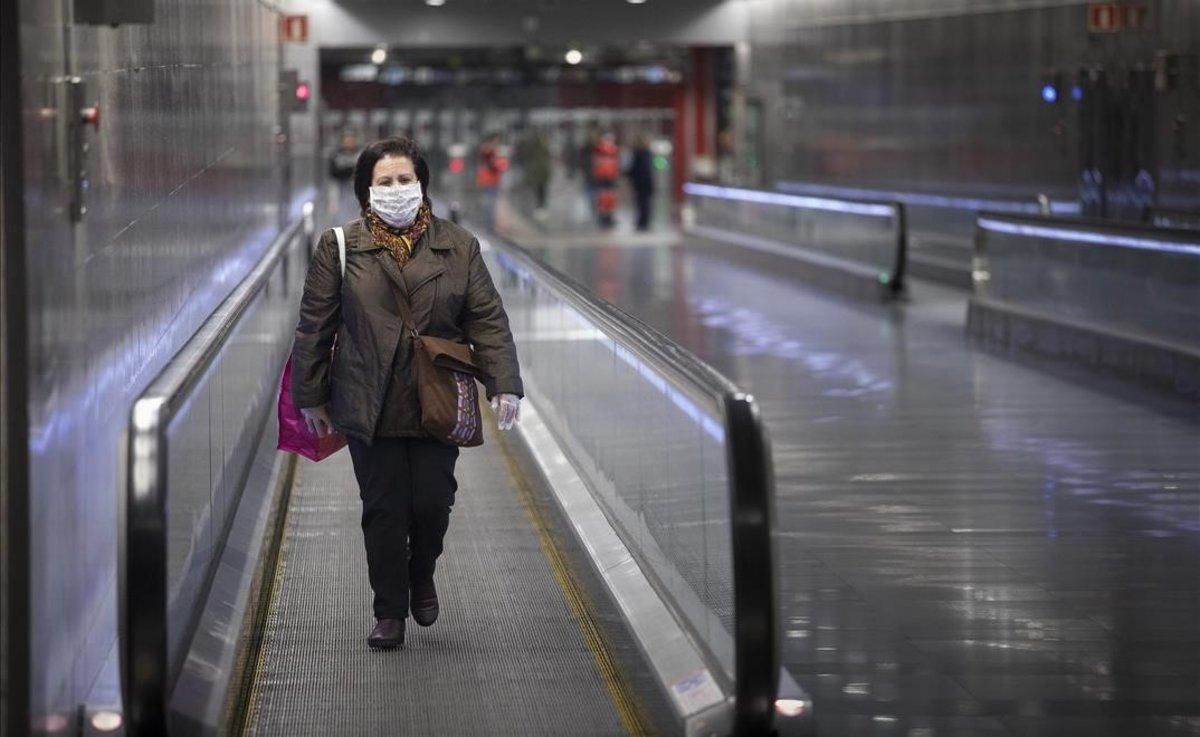 Una mujer con mascarilla para protegerse del coronavirus en la estación de metro de Diagonal, en Barcelona. Una mujer con mascarilla para protegerse del coronavirus en la estación de metro de Diagonal, en Barcelona.