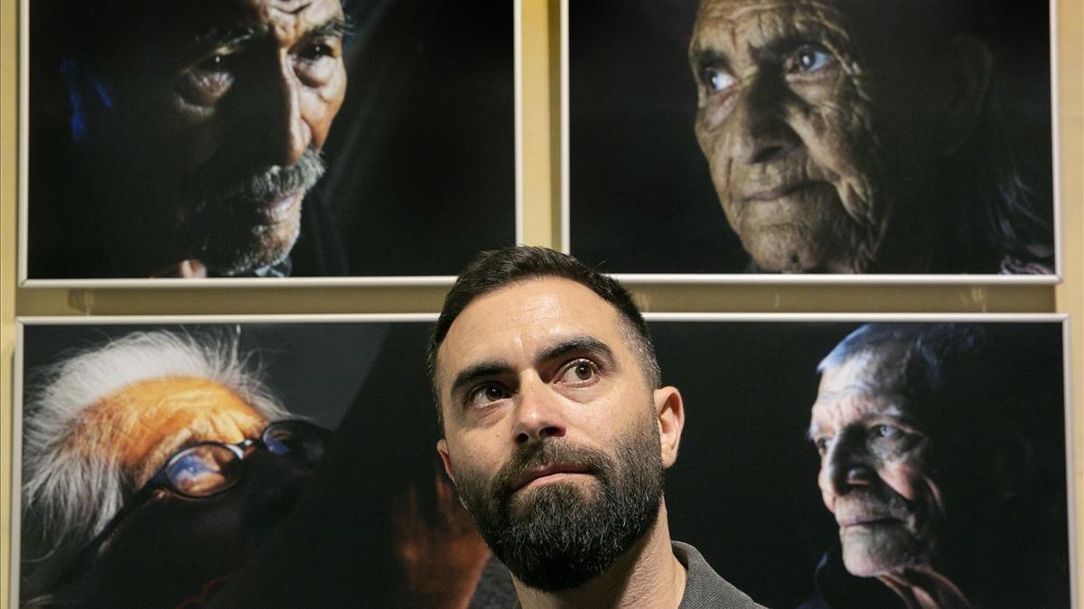 Marc Espin, autor de ’Descrtados’, posa con algunos de los retratos de la exposición 