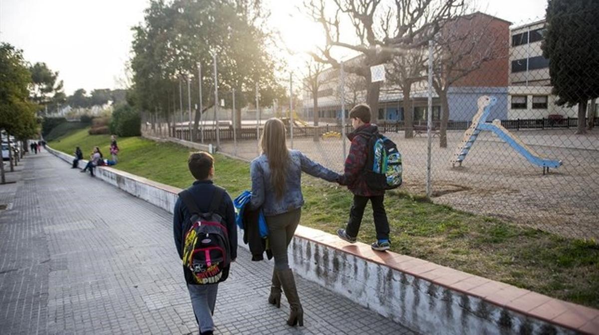 Una madre recoge a sus dos hijos, alumnos de la escuela Elisa Badia, en Barberà del Vallès.  