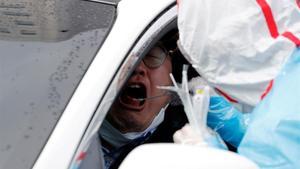 Un sanitario toma muestras a un conductor en Daegu, Corea del Sur.