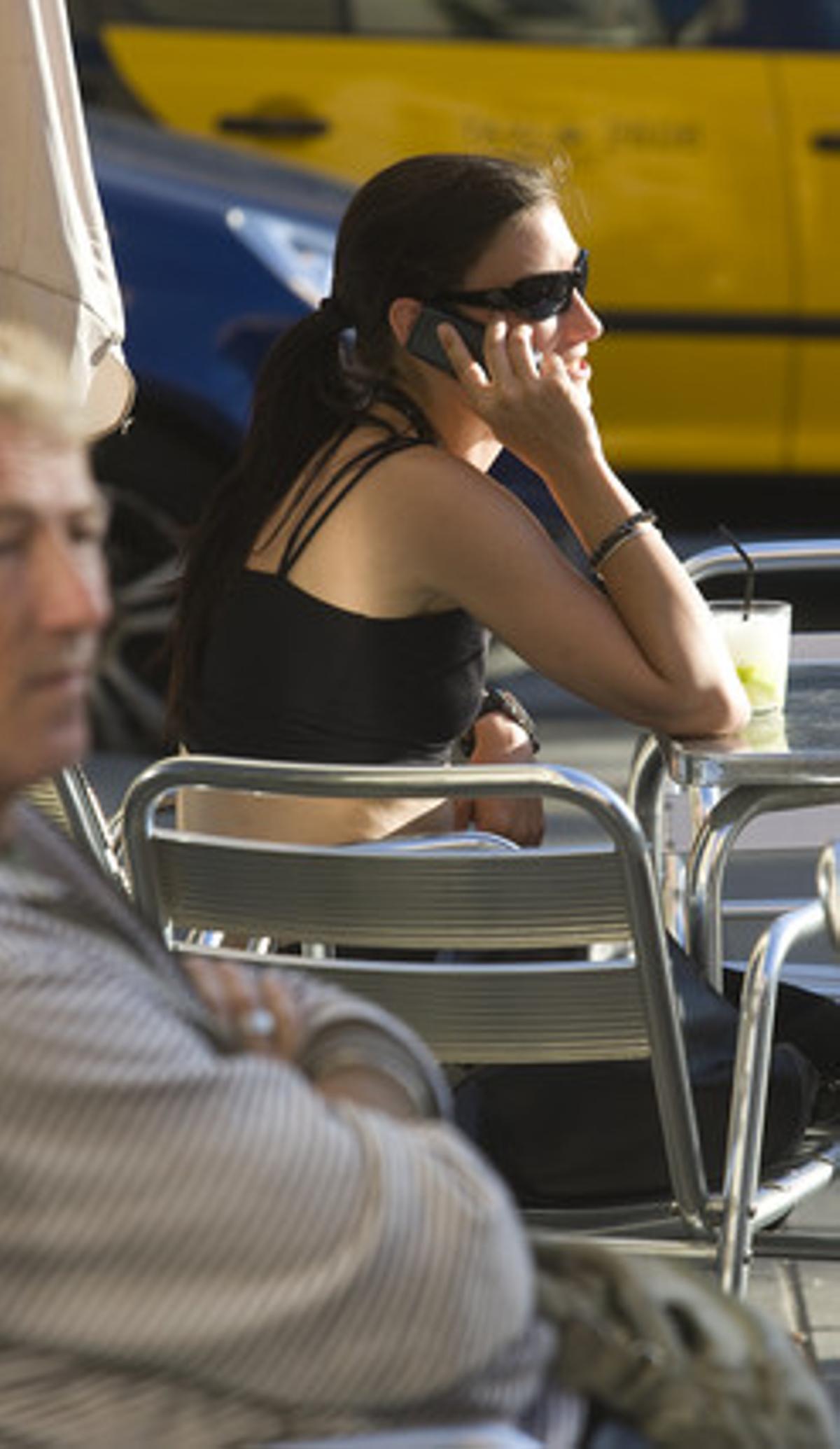 Una chica habla por teléfono móvil, en una terraza de Barcelona. Una chica habla por teléfono móvil, en una terraza de Barcelona.