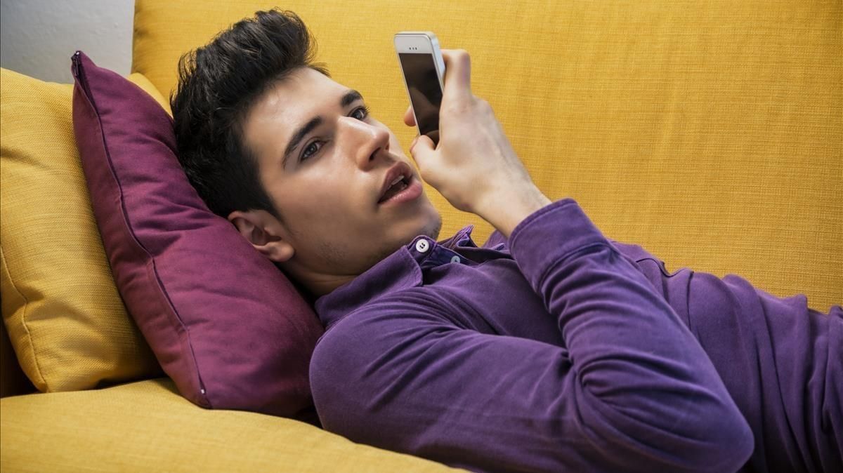 Un joven graba un audio con su móvil. Un joven graba un audio con su móvil.