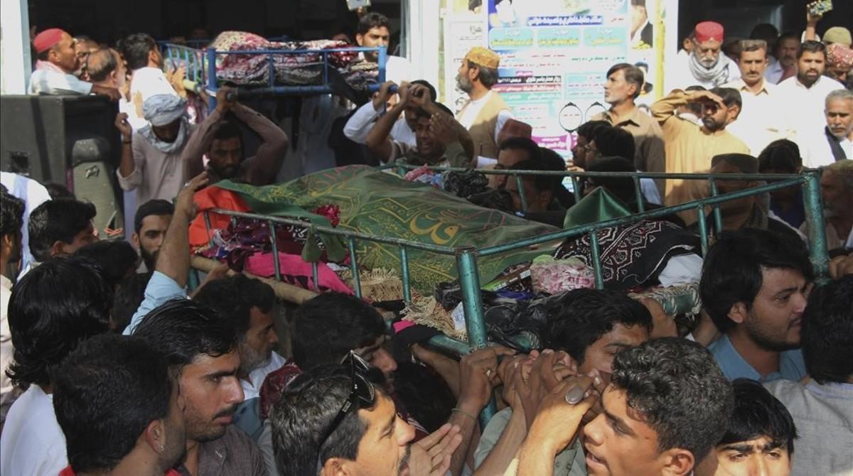 Familiares de varios asesinados asisten a su funeral tras el atentado suicida contra el templo sufí Lal Shahbaz Qalandar, en el sur de Pakistán, el 17 de febrero.