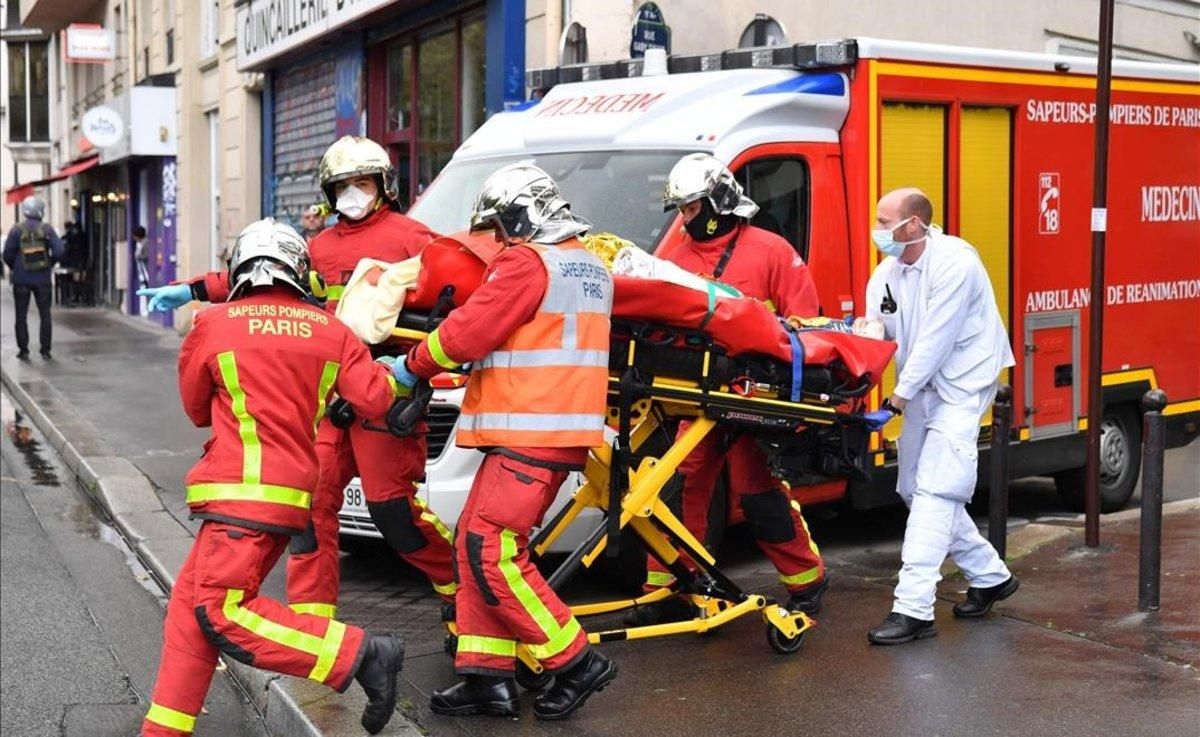 Los bomberos evacúan a un herido en el ataque cerca del semanario Charlie Hebdo. Los bomberos evacúan a un herido en el ataque cerca del semanario Charlie Hebdo.