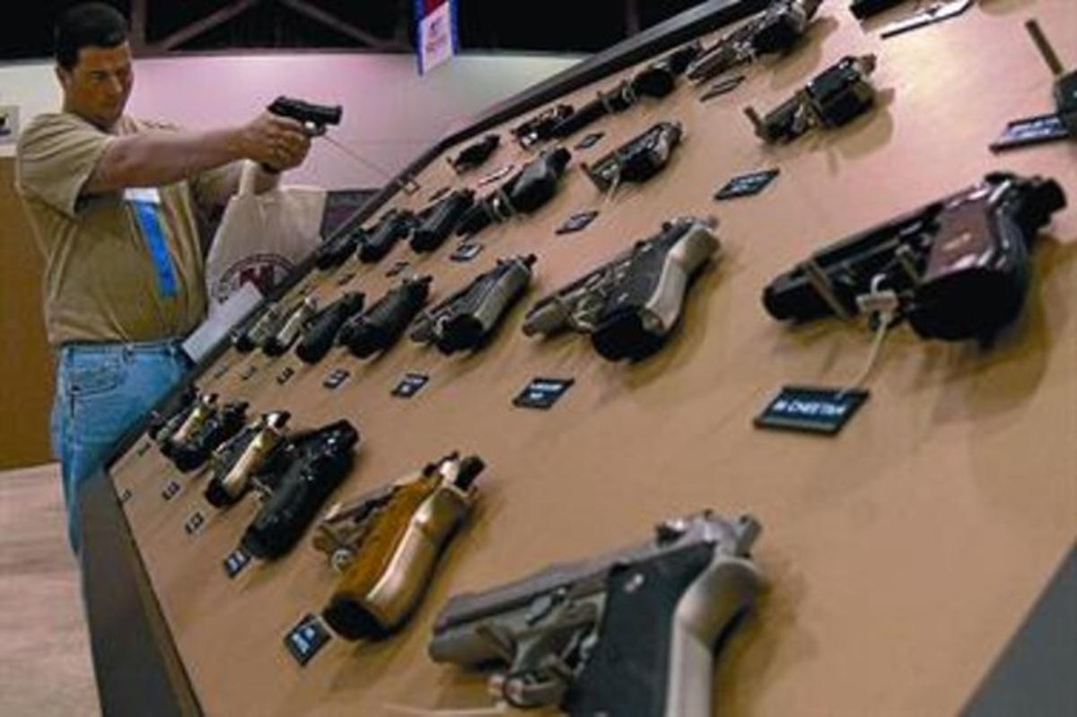 Un miembro de la Asociación Nacional del Rifle, en uno de los estands de una convención de la organización, en Kansas City.