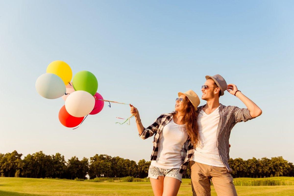 Una pareja riendo con globos. Una pareja riendo con globos.