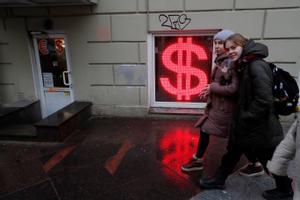 Un grupo de chicas pasan ante una oficina de cambio de divisas en San Petersburgo, este martes.