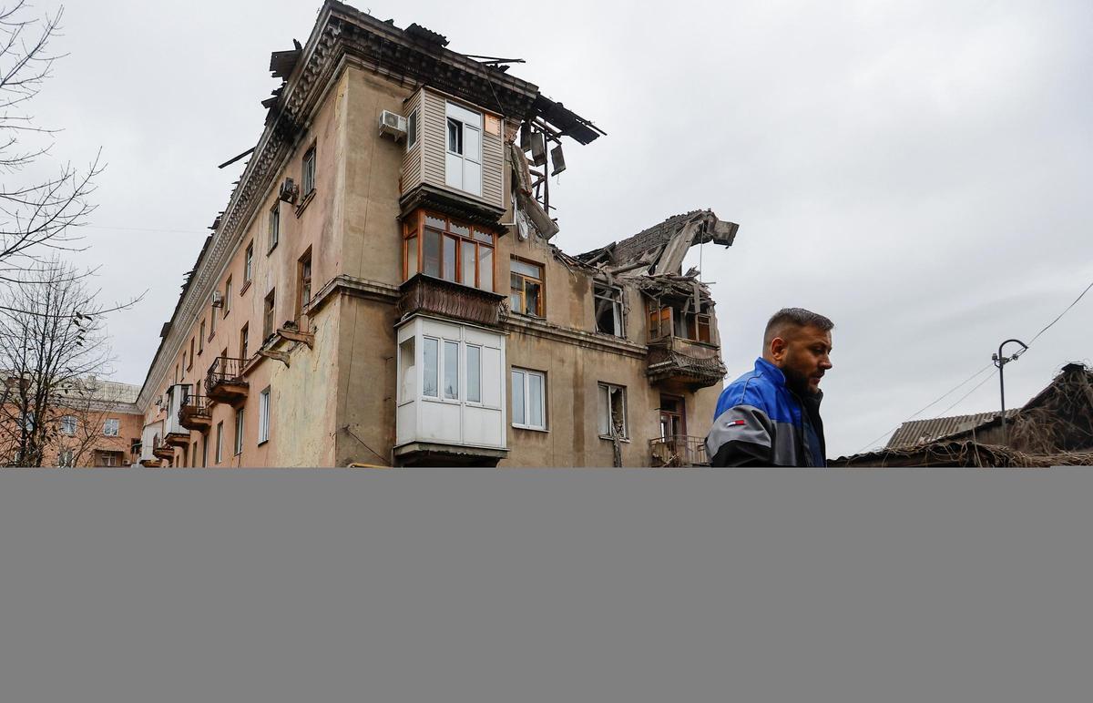 Varios civiles pasan frente a un edificio dañado por los bombardeos en Makiivka, una ciudad de Donetsk, el pasado mes de noviembre. Varios civiles pasan frente a un edificio dañado por los bombardeos en Makiivka, una ciudad de Donetsk, el pasado mes de noviembre.