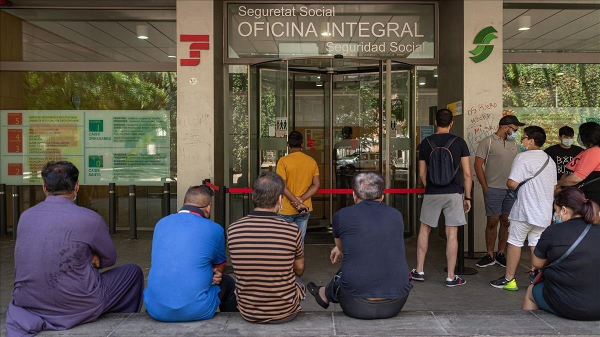 Una decena de personas haciendo cola este verano en una oficina de la Seguridad Social de Barcelona. 