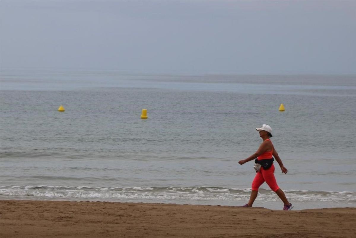 Una mujer pasea por la playa de Llevant, en Salou.