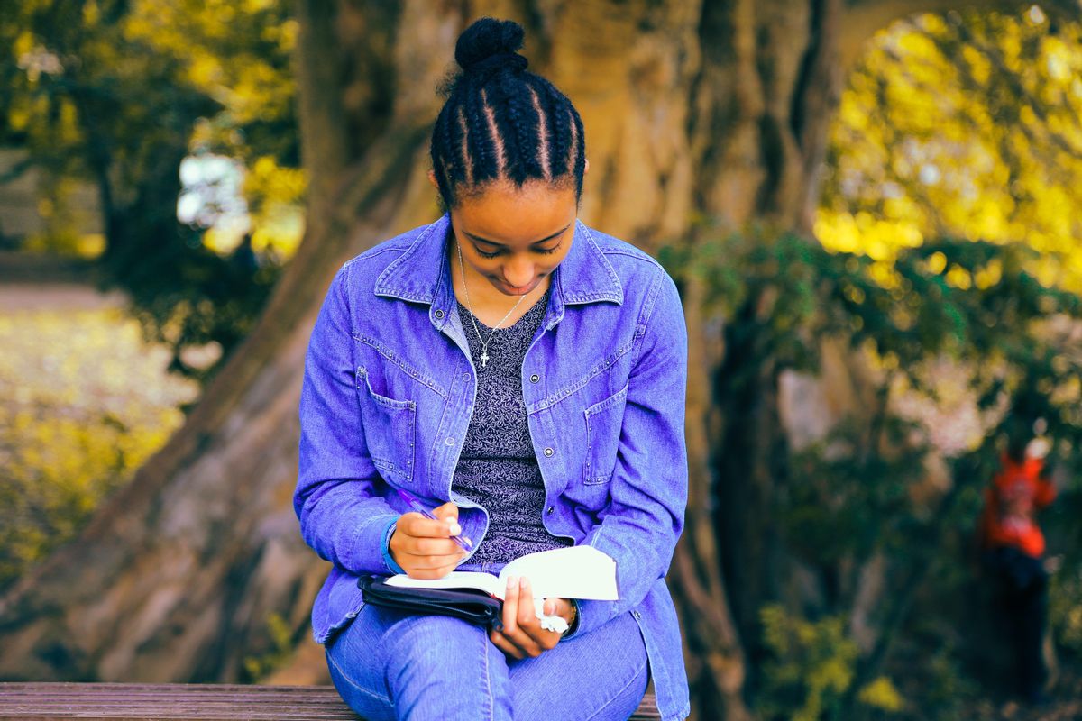 Una joven escribe en su libreta Una joven escribe en su libreta