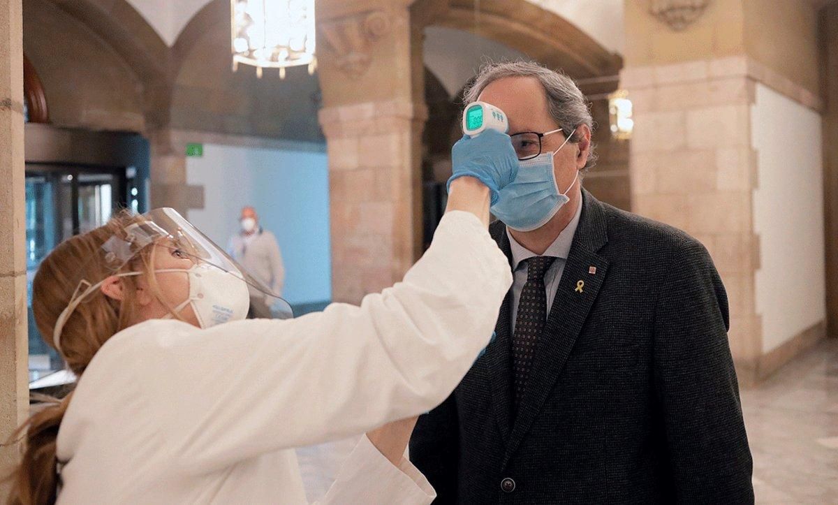 Un miembro de los servicios médicos del Parlament toma la temperatura al presidente de la Generalitat, Quim Torra, a su llegada, el 24 de abril. Un miembro de los servicios médicos del Parlament toma la temperatura al presidente de la Generalitat, Quim Torra, a su llegada, el 24 de abril.