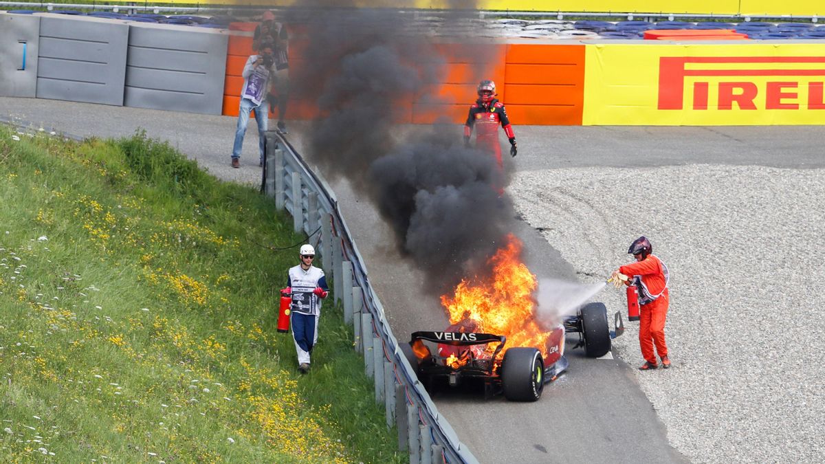 Un operario intenta sofocar el fuego en el coche de Carlos Sainz, que se incendió este domingo en el GP de Austria. Un operario intenta sofocar el fuego en el coche de Carlos Sainz, que se incendió este domingo en el GP de Austria.