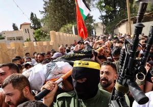 Un grupo de palestinos, algunos de ellos armados, portan el cuerpo de Samih Amarneh, fallecido por las heridas causadas durante los choque con las fuerzas de seguridad israelís en la población de Yaabad, cerca de Yenín.