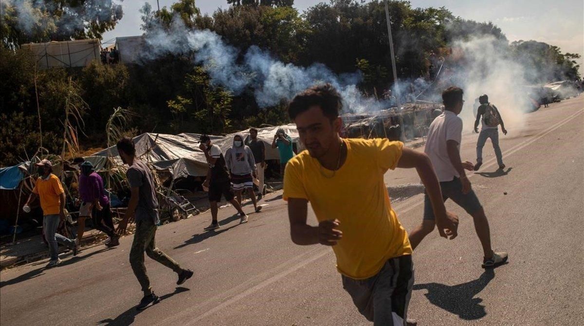 Refugiados de Moria huyen de los gases lacrimógenos lanzados por la policía griega. Refugiados de Moria huyen de los gases lacrimógenos lanzados por la policía griega.