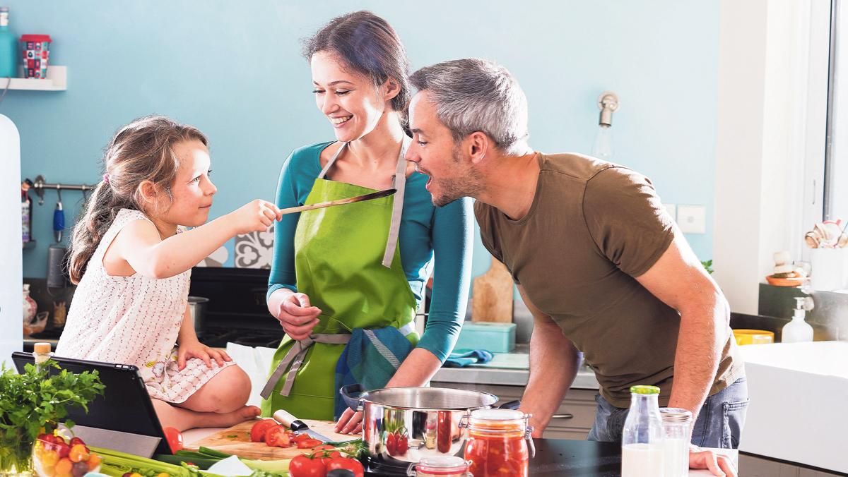 Una familia cocina en casa. Una familia cocina en casa.