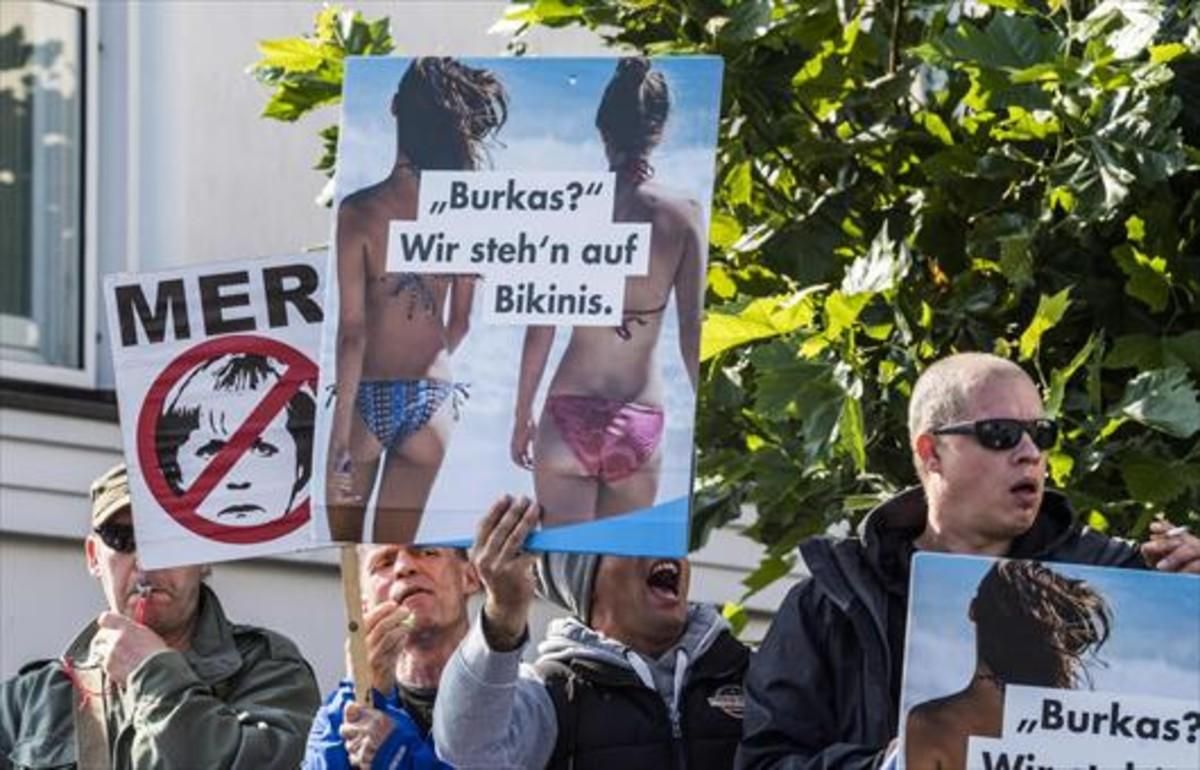 Radicales de la ultraderechista AfD exhiben pancartas contra Angela Merkel y el islam en Ostseebad Bliz, al norte de Alemania. Radicales de la ultraderechista AfD exhiben pancartas contra Angela Merkel y el islam en Ostseebad Bliz, al norte de Alemania.