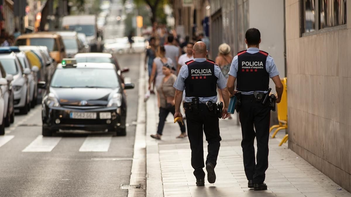 Una pareja de Mossos patrulla por una calle de Barcelona. Una pareja de Mossos patrulla por una calle de Barcelona.