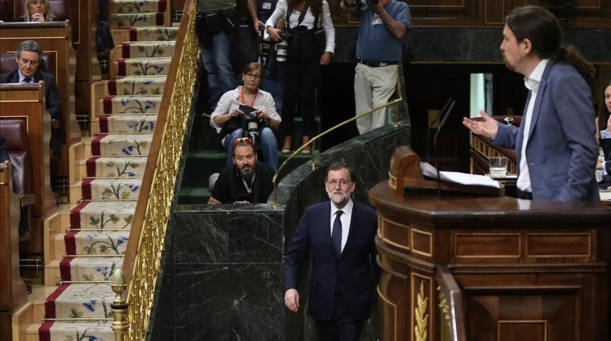 Mariano Rajoy vuelve a su escaño tras unos minutos fuera del hemiciclo mientras Pablo Iglesias habla en la tribuna. Mariano Rajoy vuelve a su escaño tras unos minutos fuera del hemiciclo mientras Pablo Iglesias habla en la tribuna.