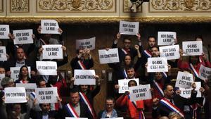 Diputados de izquierda muestran carteles contra la reforma de las pensiones tras fracasar la moción de censura contra el Gobierno francés, este lunes.