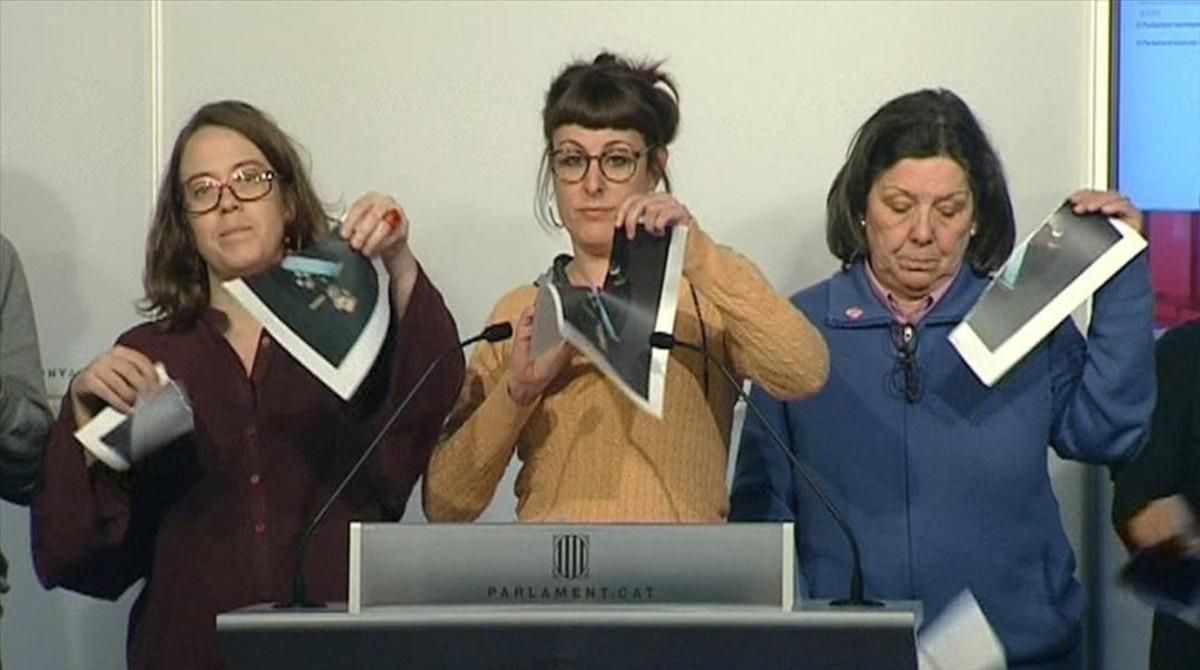 Las diputadas de la CUP Eulàlia Reguant, Mireia Vehí y Gabriela Serra rompen fotos del Rey en una rueda de prensa en el Parlament. Las diputadas de la CUP Eulàlia Reguant, Mireia Vehí y Gabriela Serra rompen fotos del Rey en una rueda de prensa en el Parlament.