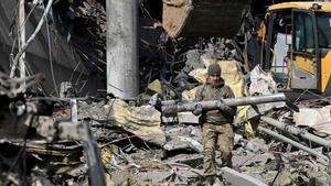 Un soldado ucraniano sostiene un fragmento de misil tras el ataque ruso a un edificio en Kiev.
