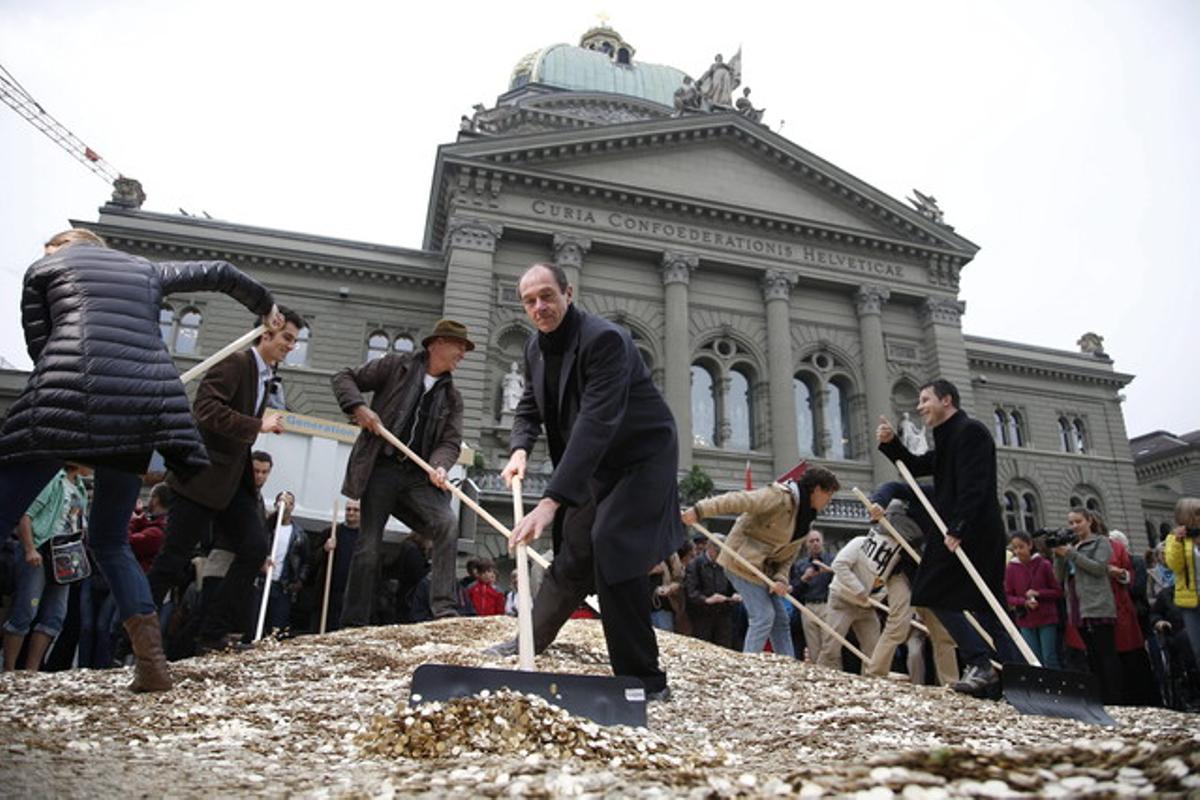 Activistes col·loquen cèntims a terra a les portes del Parlament a Berna, el dia 4 de setembre.