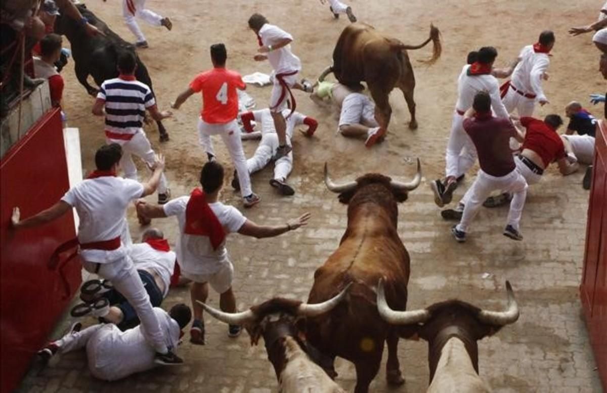 Varios mozos pasan apuros ante los toros de la ganaderia de Yeltes en el tramo del Callejón durante el cuarto encierro de San Fermín del 2016. Varios mozos pasan apuros ante los toros de la ganaderia de Yeltes en el tramo del Callejón durante el cuarto encierro de San Fermín del 2016.