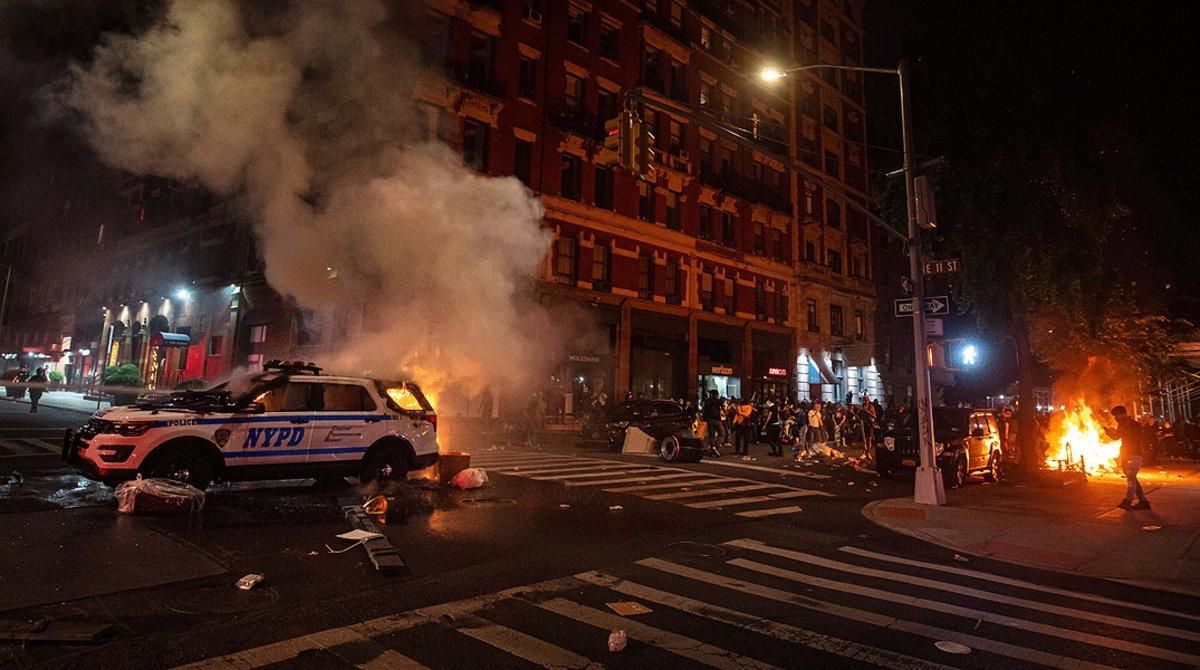 Un numeroso grupo de manifestantes observan cómo arde un coche de la policía en Manhattan, este sábado 30 de mayo, durante las protestas por la muerte de George Floyd en Minneápolis. Un numeroso grupo de manifestantes observan cómo arde un coche de la policía en Manhattan, este sábado 30 de mayo, durante las protestas por la muerte de George Floyd en Minneápolis.