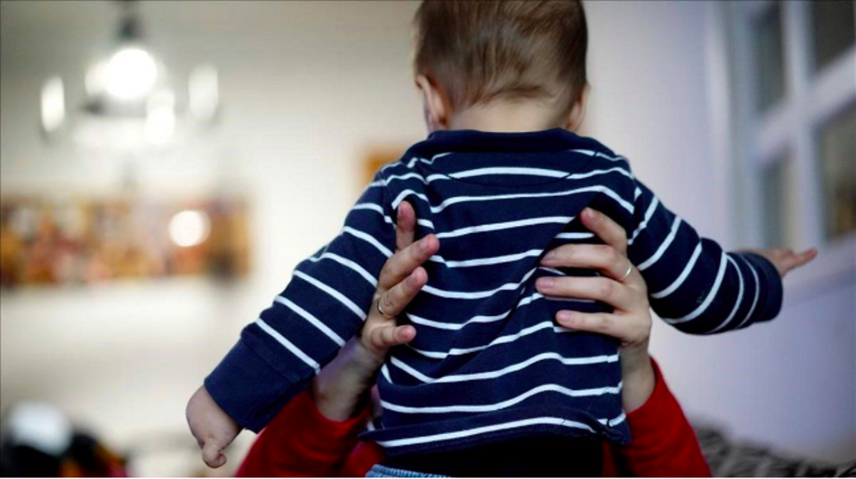 Una madre sostiene a su bebé en su casa de Madrid