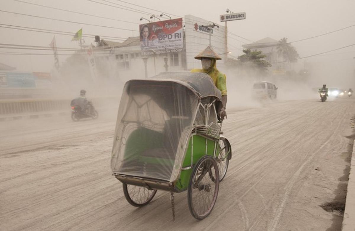 Un indonesio circula por una carretera de Yogyakarta cubierta de ceniza y arena del volcán Kelud, este viernes.
