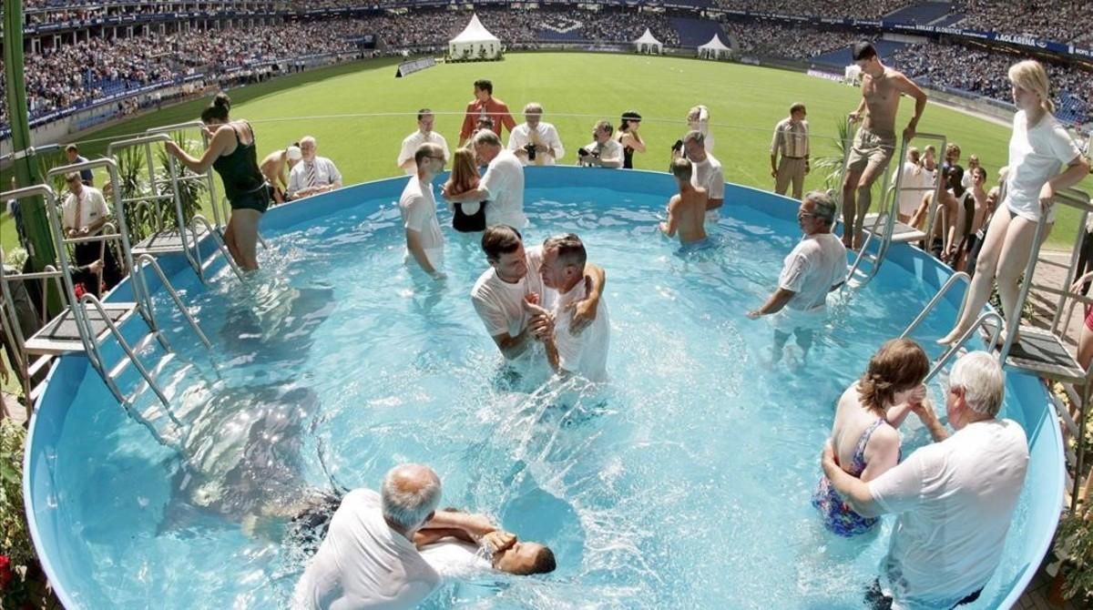 Asistentes al congreso especial de los Testigos de Jehová son bautizados durante una ceremonia múltiple. Asistentes al congreso especial de los Testigos de Jehová son bautizados durante una ceremonia múltiple.