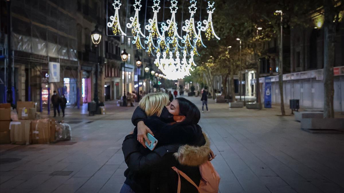 Dos amigas se dan un abrazo bajo las luces de Navidad del Portal de l’Àngel, en Barcelona. Dos amigas se dan un abrazo bajo las luces de Navidad del Portal de l’Àngel, en Barcelona.