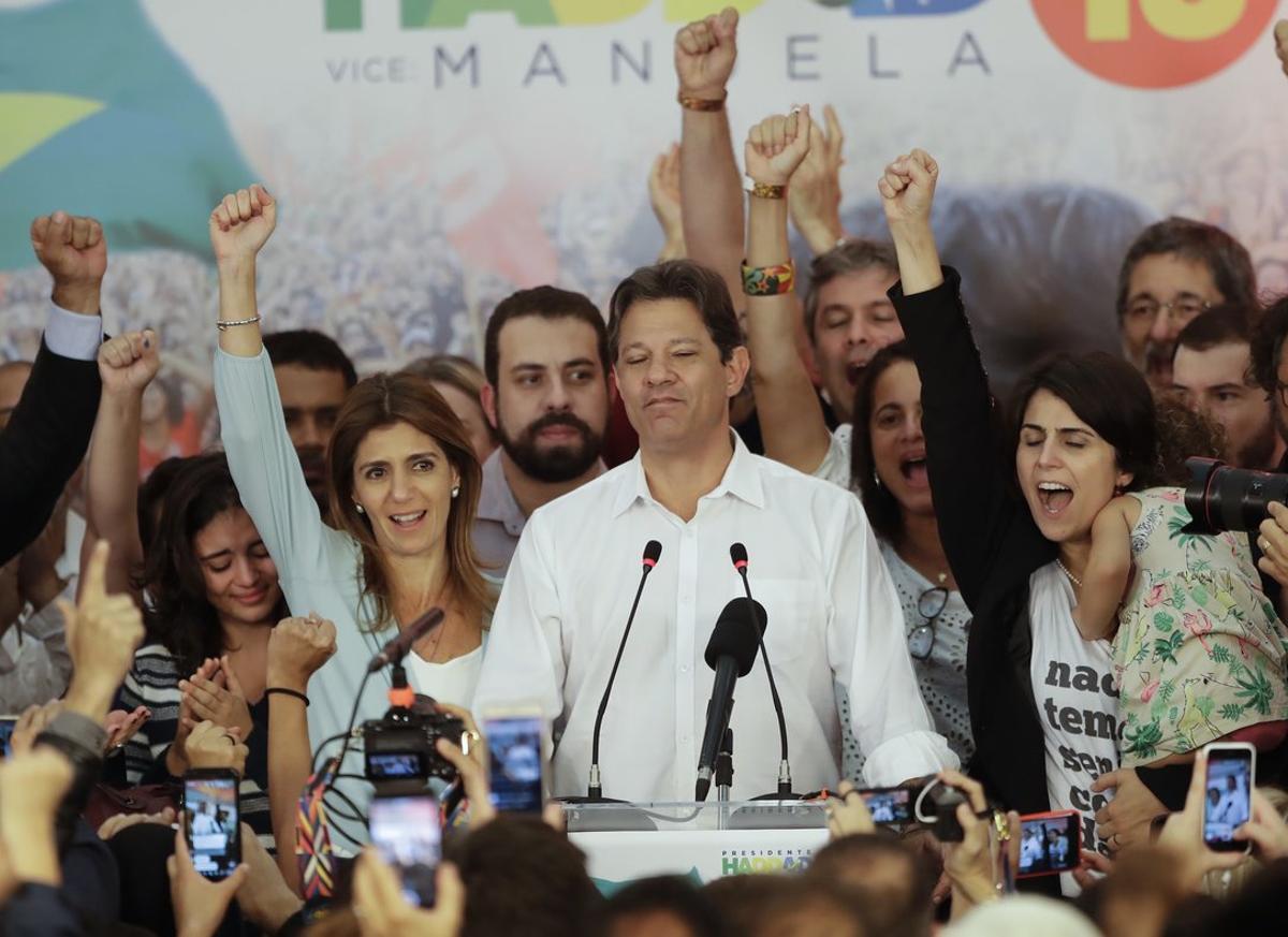 Flanked by his wife Ana Estela  left  and running mate Manuela d Avila  Workers  Party presidential candidate Fernando Haddad pauses during his concession speech while his staff and supporters cheer him on  in Sao Paulo  Brazil. Supreme Electoral Tribunal declared far-right congressman Jair Bolsonaro the next president of Latin Americaa  s biggest country   AP Photo Andre Penner 