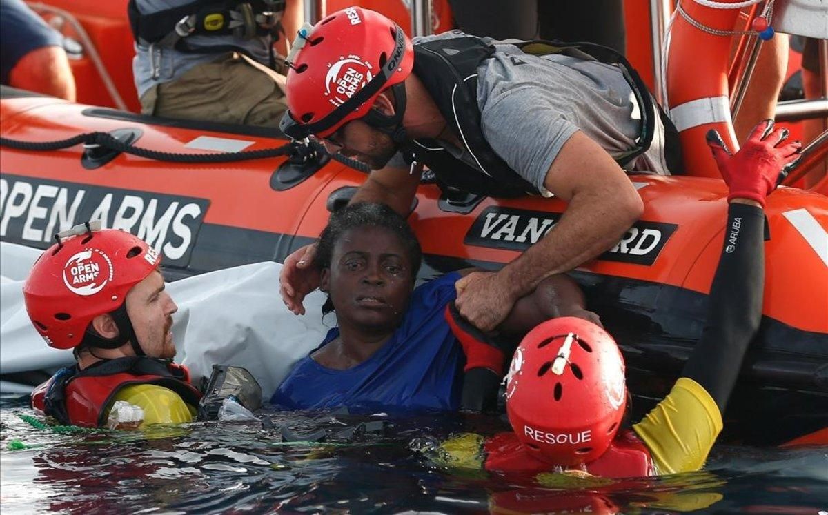 Miembros de Open Arms rescatan a una inmigrante camerunesa que trataba de sobrevivir en el Mediterráneo después de que su patera naufragara. Miembros de Open Arms rescatan a una inmigrante camerunesa que trataba de sobrevivir en el Mediterráneo después de que su patera naufragara.