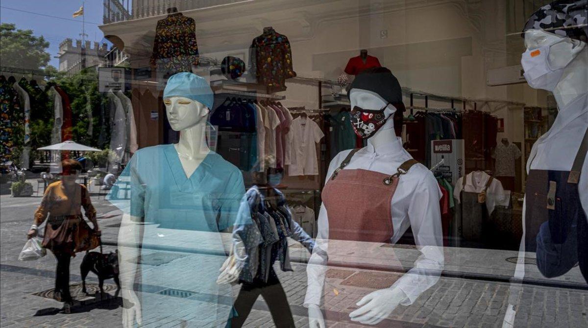 Maniquís con mascarilla en una tienda de Valencia. Maniquís con mascarilla en una tienda de Valencia.